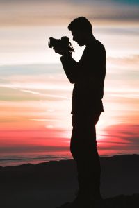 student with a digital camera on creative photography practice